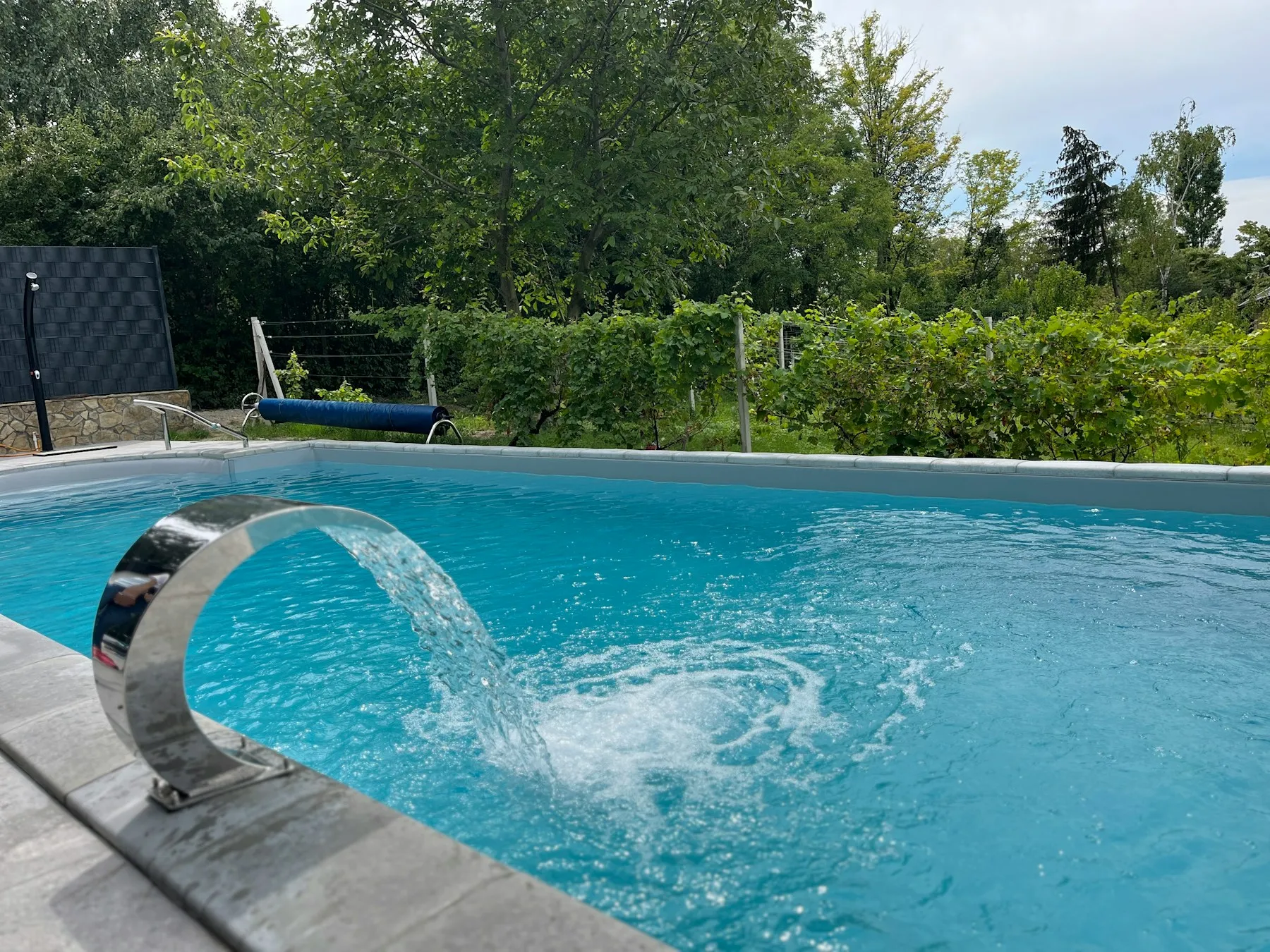 Getto d'acqua che ricade in una piscina fuori terra in giardino